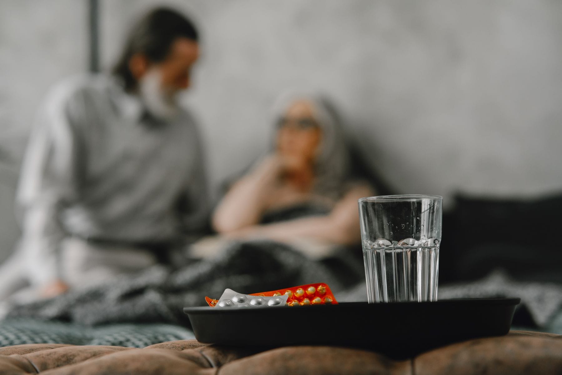 Ouder echtpaar bespreekt medicatie thuis op een warme dag
